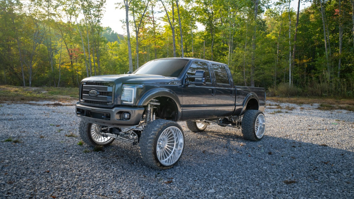 Blue Collar, a lifted 2015 Ford F-350, front three-quarter view on a gravel lot