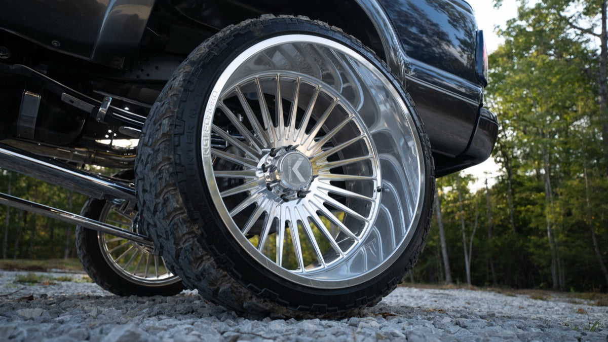 Close-up of a polished multi-spoke wheel and tire on Blue Collar