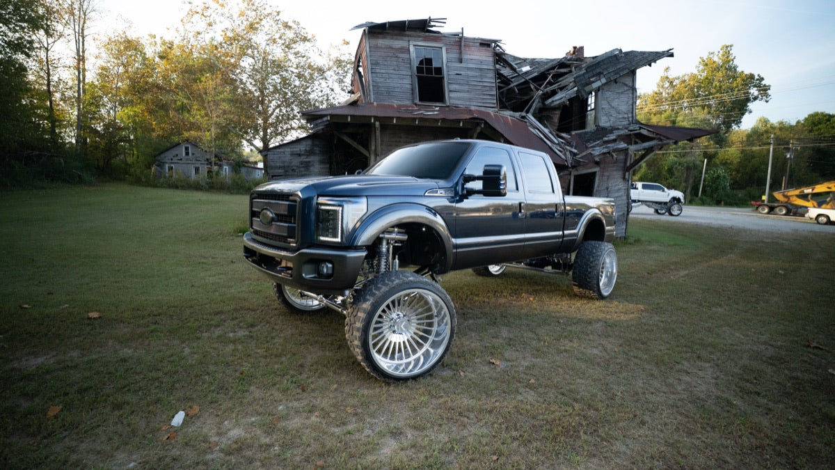 Blue Collar parked in front of a weathered wooden barn
